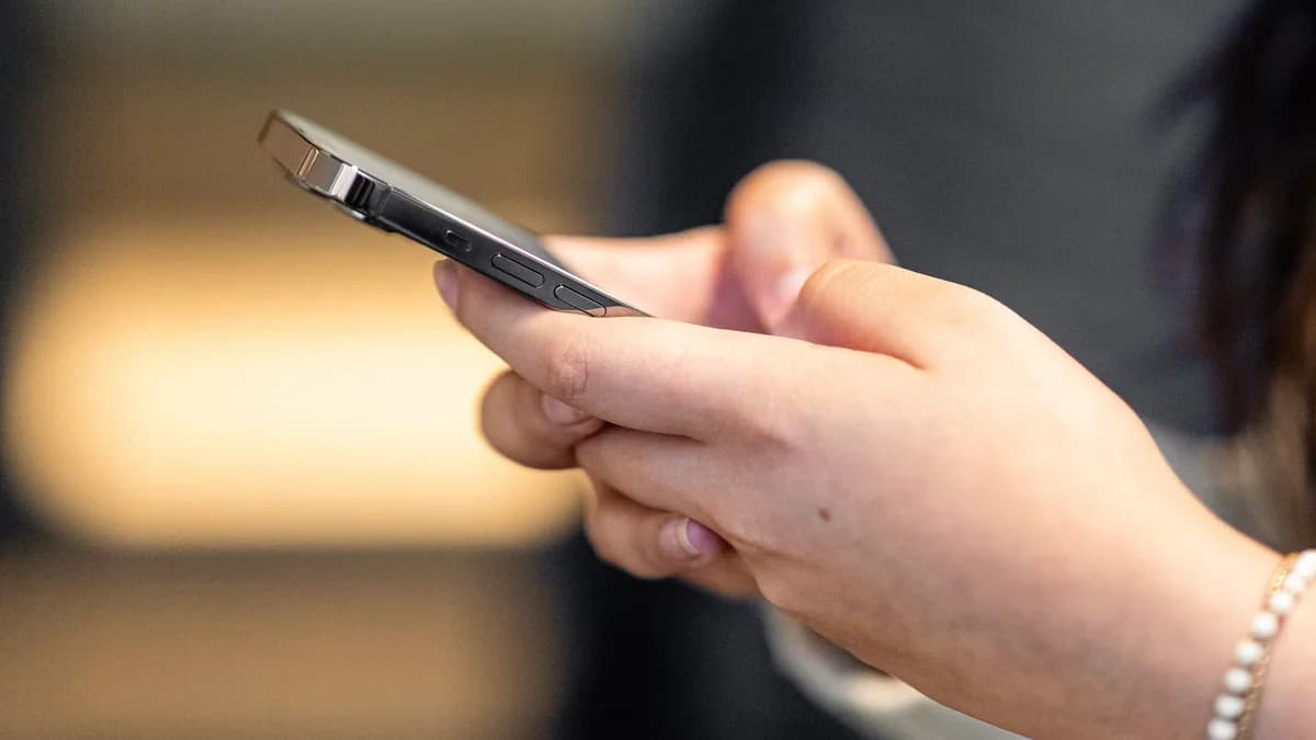Woman holding a smartphone while browsing a social media feed