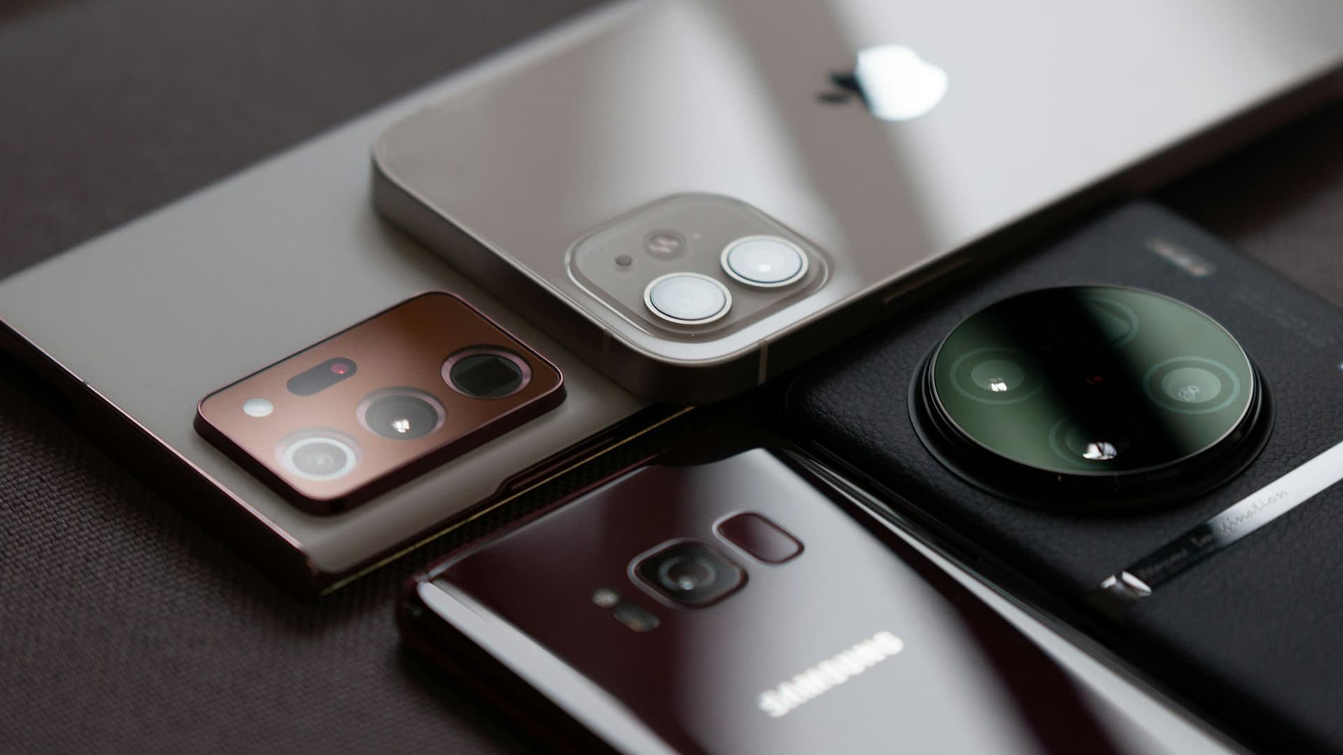 Several smartphones laid out together on a table