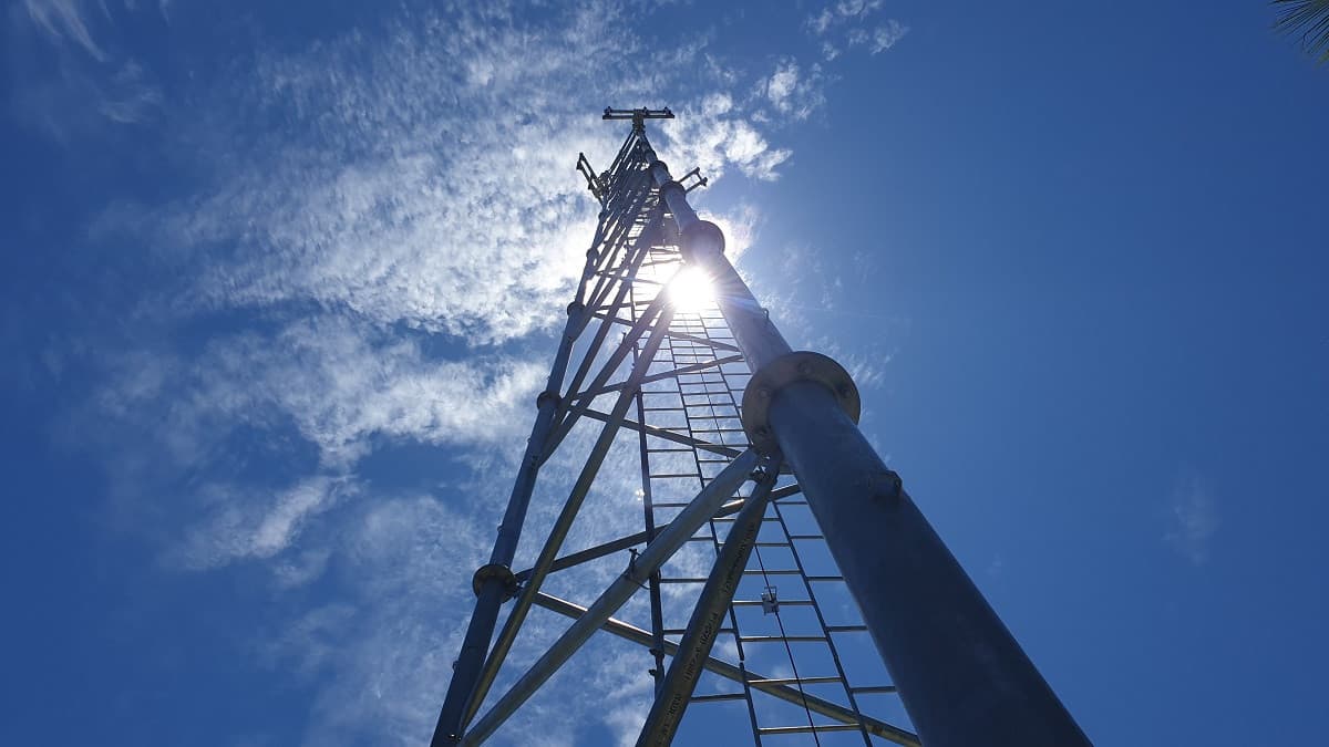 Telecommunications tower silhouetted against a dramatic cloudy sky